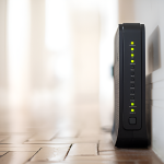 router on the floor, leaning against a white wall